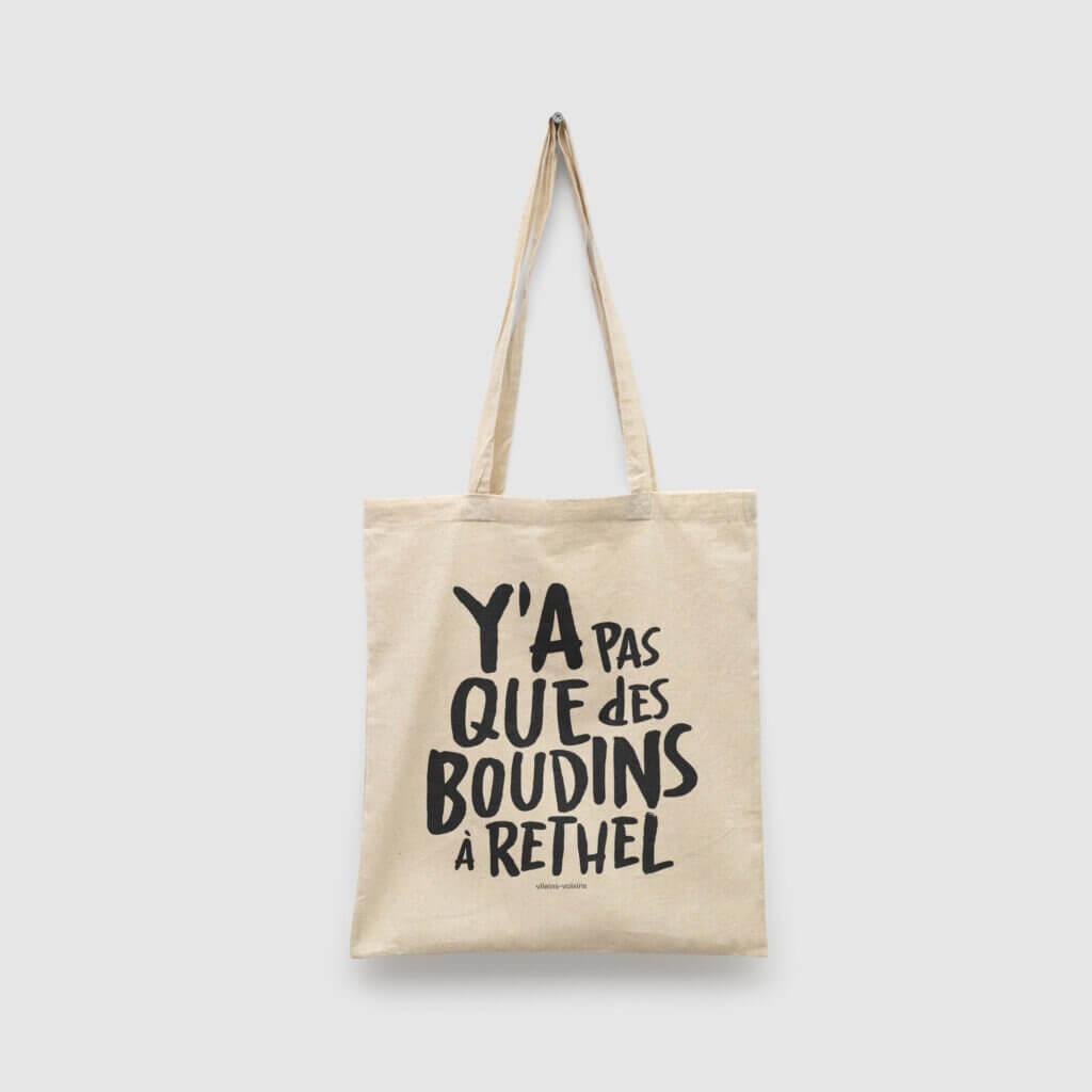 Tote bag naturel, avec le texte y'a pas que des boudins à Rethel en noir, de vilains-voisins imprimerie et studio de design graphique à Rethel, dans les Ardennes.